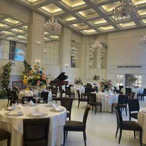 白を基調とした披露宴会場。天井が高く開放感を感じられ外からの光もめいいっぱい入ってくる明るい会場。