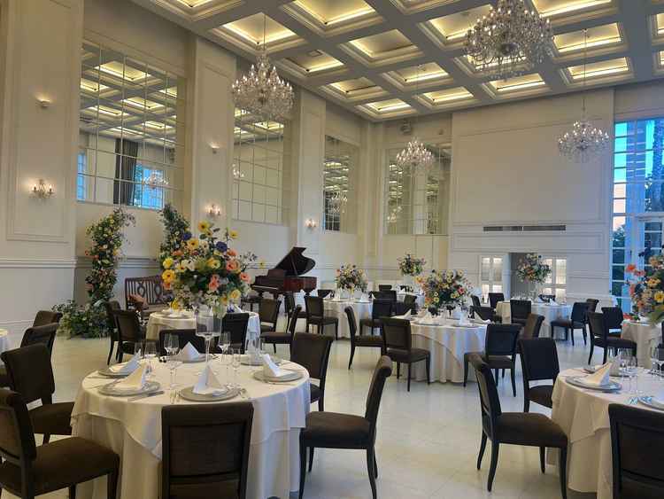 白を基調とした披露宴会場。天井が高く開放感を感じられ外からの光もめいいっぱい入ってくる明るい会場。