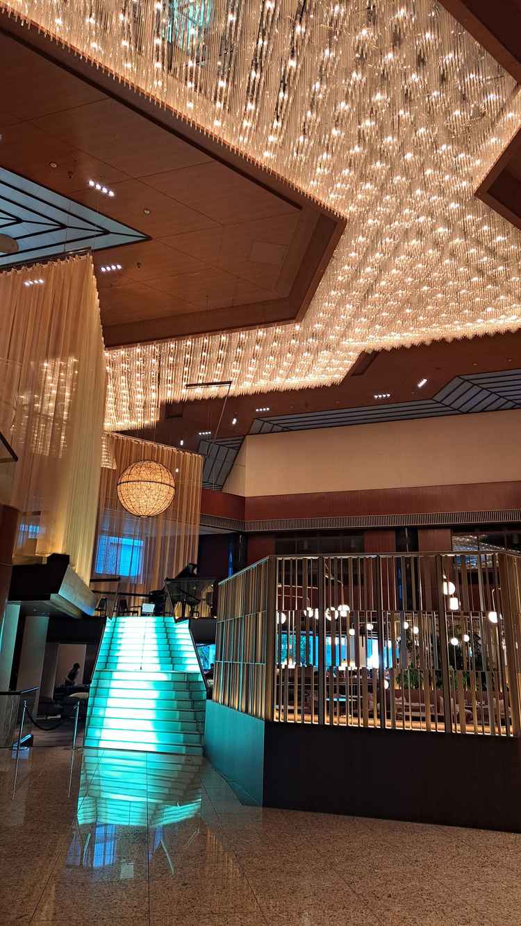 ロビー横の光る階段と、天の川と月を模した天井のライティング