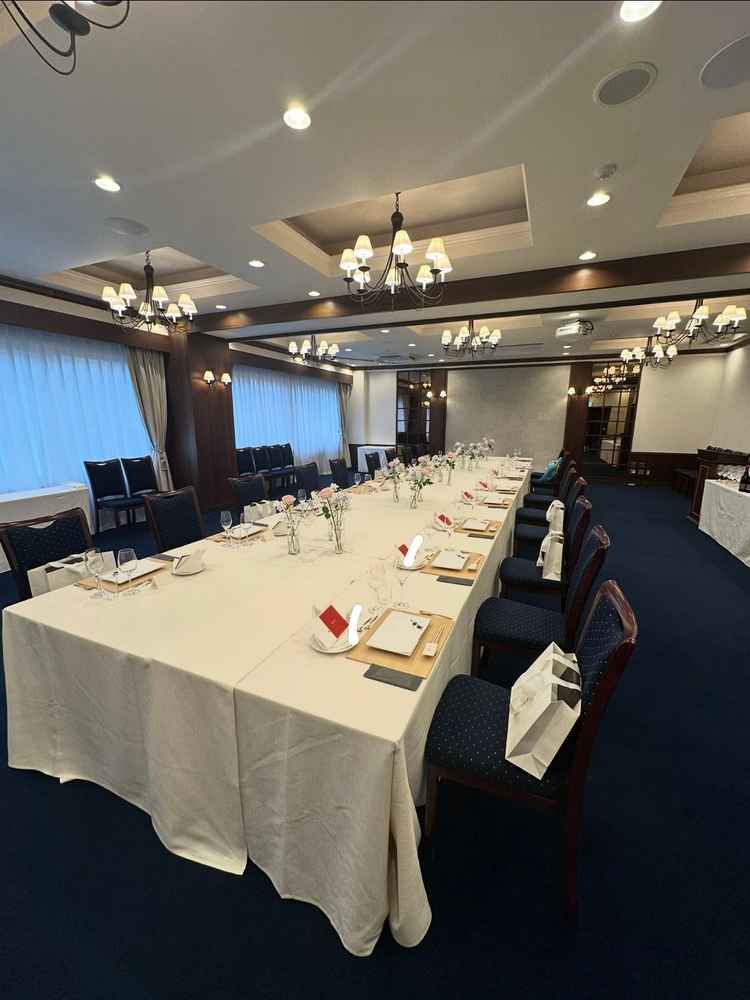 披露宴会場全体像の写真。長テーブルのレイアウトが親族のみの披露宴にマッチしそうだと感じた。