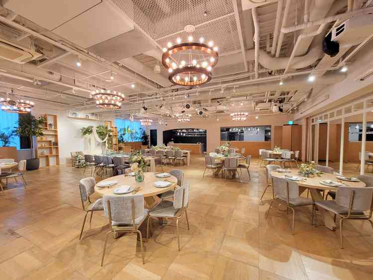 円卓がゆったりと配置され、ナチュラルな装花やグリーンが空間に彩りを感じる居心地のよい空間でした。？