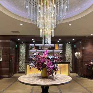 披露宴会場。エレベーター降りてからの景色。シャンデリアや大きなお花が置いてあり豪華さを感じた。