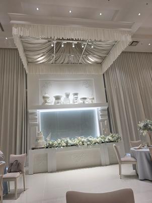 披露宴会場の新郎新婦の席の写真。天井が高くとにかく全てが真っ白で、床まで真っ白でなのがポイントです。