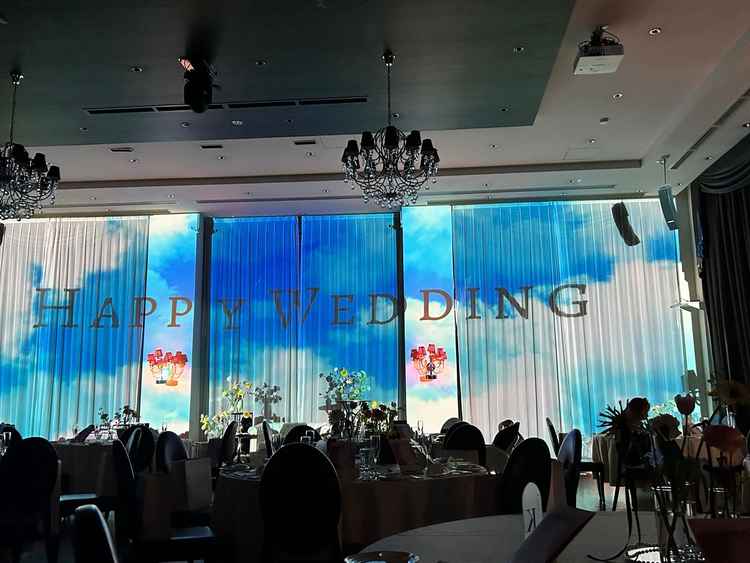 披露宴会場はモダンな雰囲気もありつつ、壁一面に映像を映す大胆なプロジェクションマッピングが魅力的。