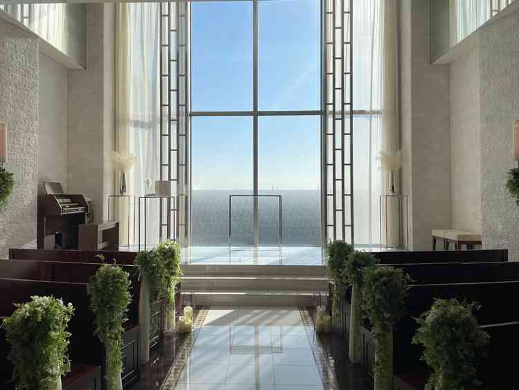 空を近くに感じる特別な空間で、真っ白なバージンロードに自然光が反射する美しいチャペル。