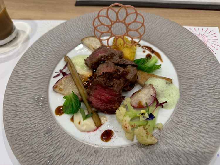 試食のメイン料理。牛肉で柔らかく、温かいまま提供される。桜木町の観覧車をイメージしたパリパリが付く。