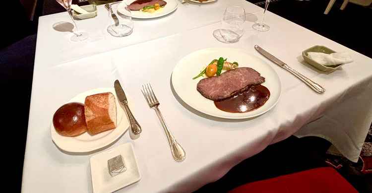 看板メニューのお肉料理と手作りのパン