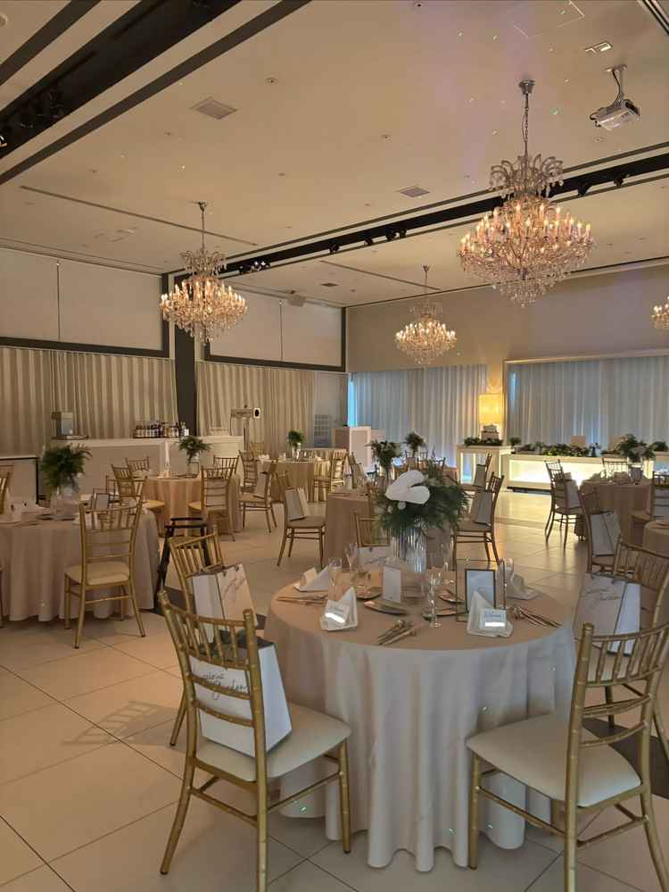 披露宴会場。白基調で椅子がゴールドでオシャレでした！装花は生花と造花を選べます。高砂はソファも選べる