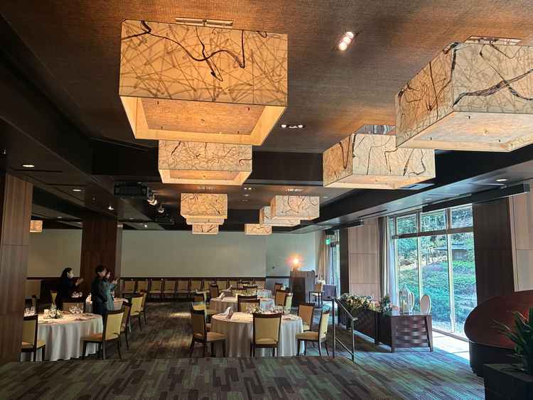 モダンな雰囲気の披露宴会場。新郎新婦の方を見ると圧巻な庭園眺めることができる。