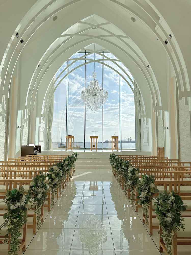 大きなシャンデリアと共に羽が降り注ぐ演出にもこだわったオーシャンビューのチャペル。
