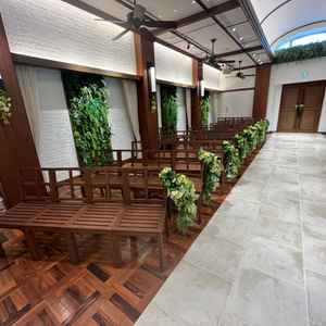 ブラウンのベンチとグリーンの装花が並び、自然をイメージした落ち着いた雰囲気でした。