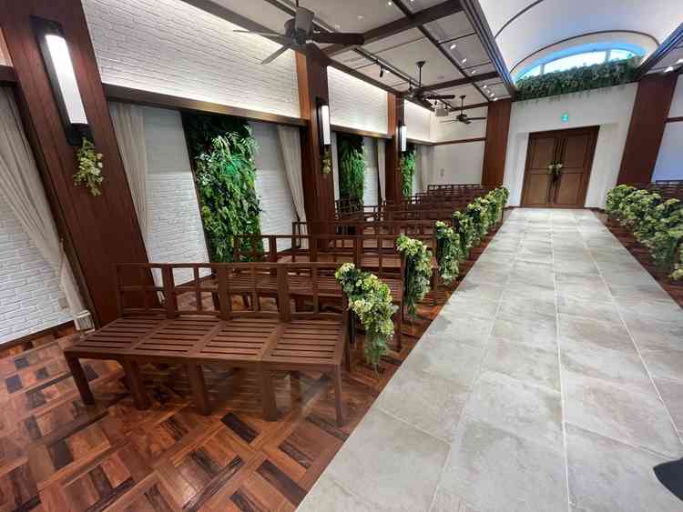 ブラウンのベンチとグリーンの装花が並び、自然をイメージした落ち着いた雰囲気でした。