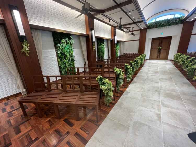 ブラウンのベンチとグリーンの装花が並び、自然をイメージした落ち着いた雰囲気でした。