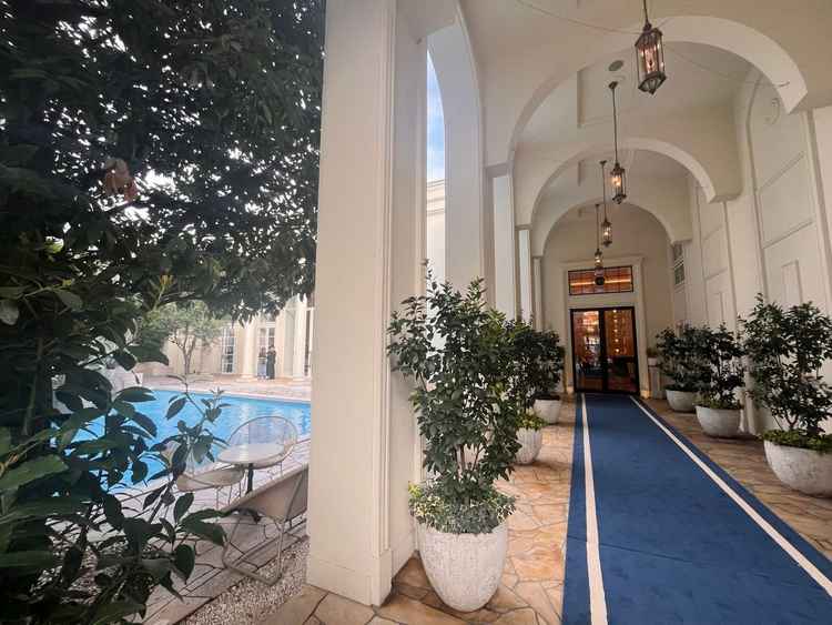 青いカーペットが映える入口と広々としたプール。