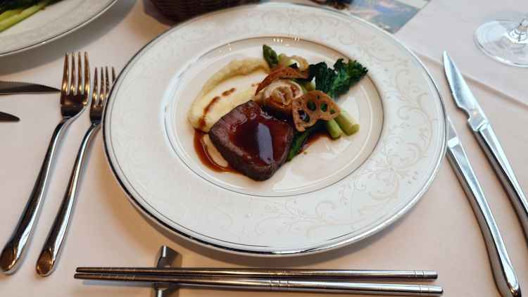 試食のステーキ。周りに野菜やマッシュポテトも添えられている。