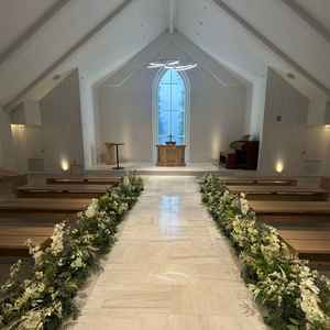 式場。新式が行われる　白が貴重　椅子はもう少しこだわりたい。新郎新婦と参列者の距離が近い