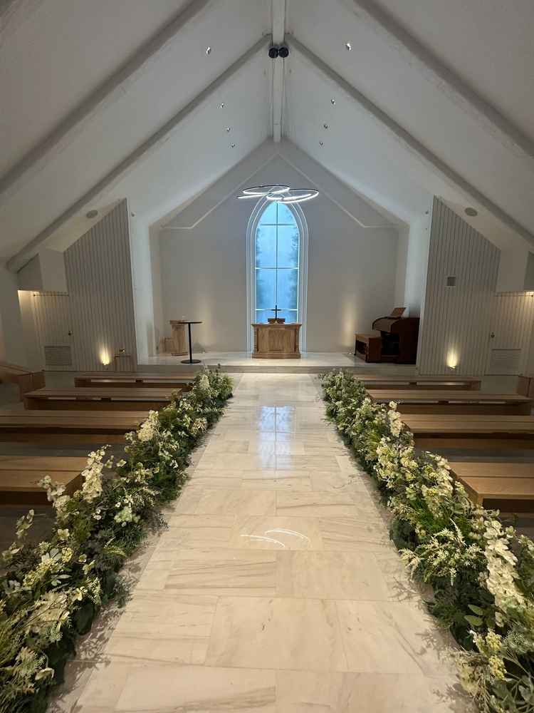 式場。新式が行われる　白が貴重　椅子はもう少しこだわりたい。新郎新婦と参列者の距離が近い