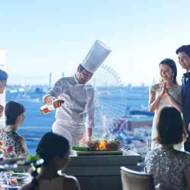 ＹＯＫＯＨＡＭＡ　ＭＯＮＯＬＩＴＨ（横浜モノリス） パノラマビューを背景にシェフの料理説明やフランベショーなど、多彩な演出を愉しんで
