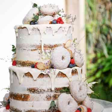 インフィニート 名古屋<エルフラットグループ> ホワイトで統一されたクリームとアクセントのドーナッツが可愛らしいケーキデサイン