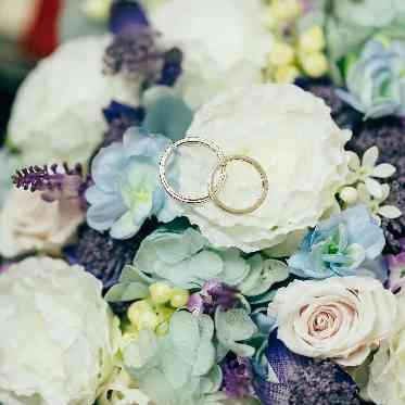 花束からのぞく結婚指輪もキュート。