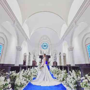 花嫁様のウェディングドレス姿が綺麗に映えるロイヤルブルーのバージンロード