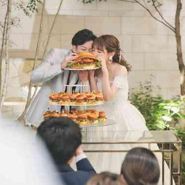トップの巨大なハンバーガータワーにかぶりつき！食いしん坊な可愛いワンシーンです！