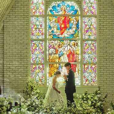 マリエルコートインターパーク 19世紀の欧州で作られたステンドグラスからの七色の光がバージンロードに映り込む