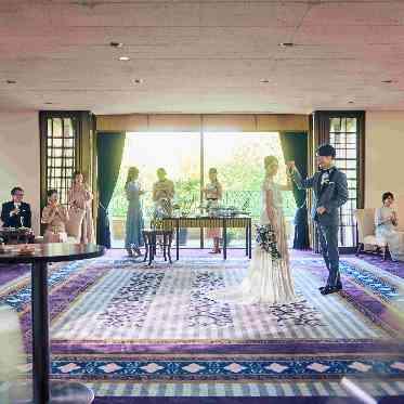 ホワイエから望む正面の公園の緑を背景にウエルカムパーティやデザートビュッフェを