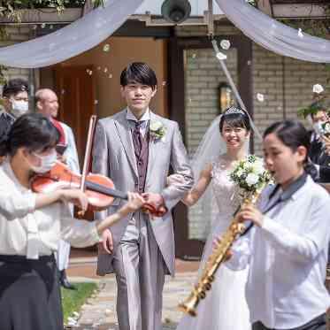 HOTEL PLAZA KOBE(ホテルプラザ神戸) フラワーシャワーでヴァイオリンとサックスがおふたりを先導♪まるで映画のワンシーン