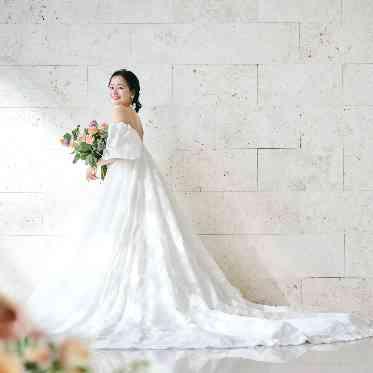 グレイスヒル・オーシャンテラス チャペルの壁をバックにドレスショット