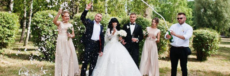 Stylish wedding couple, groomsman and bridesmaids with champagne explosion.