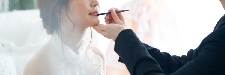 スタイリストが新婦に口紅を差す様子