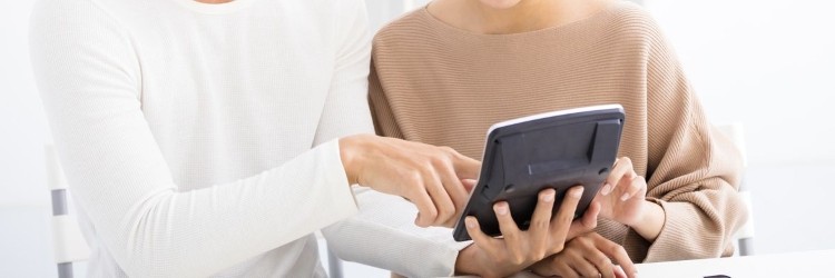 電卓を使って費用を計算するカップルの手元