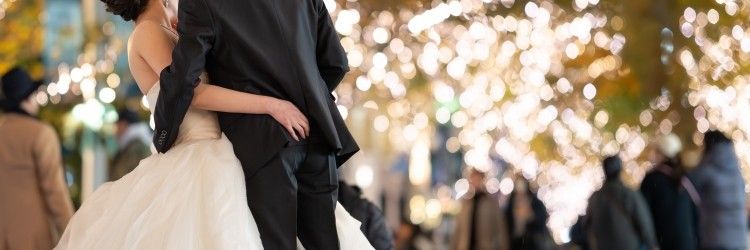 イルミネーションの中で抱き合う新郎新婦の後ろ姿