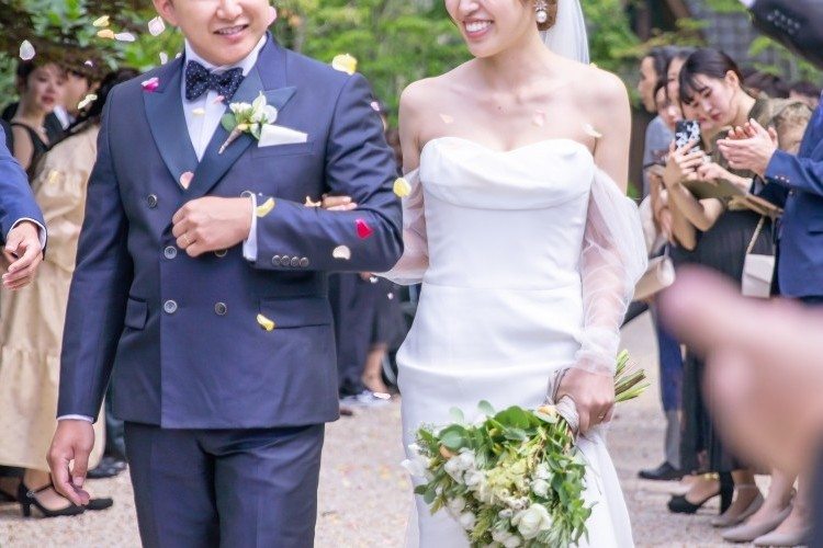 ゲストからのフラワーシャワーで祝福される新郎新婦