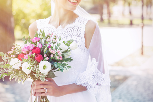 ブーケを持ち微笑むウエディングドレス姿の新婦